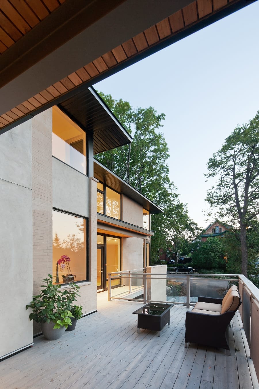 John Donkin Architect - An exterior picture of an outdoor seating area with glass and wood railings on a beautiful, modern home designed by John Donkin Architect.
