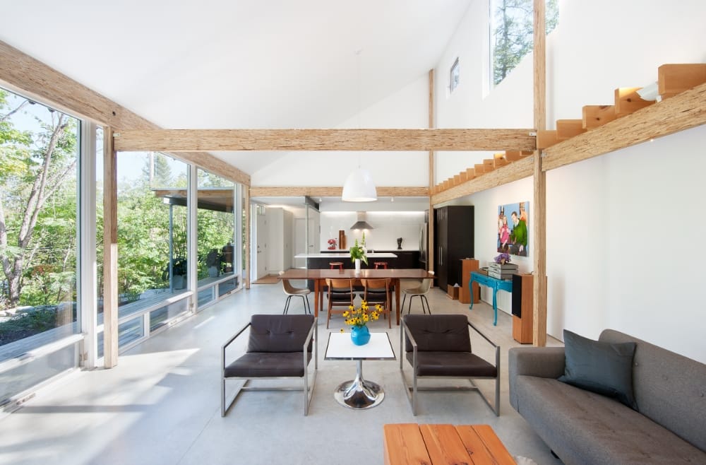 John Donkin Architect - A spacious, open concept living room, dining area and kitchen with floor to ceiling windows along its entire wall. House was designed by John Donkin Architect, an Ottawa-based company specializing in modern construction, additions and renovations.